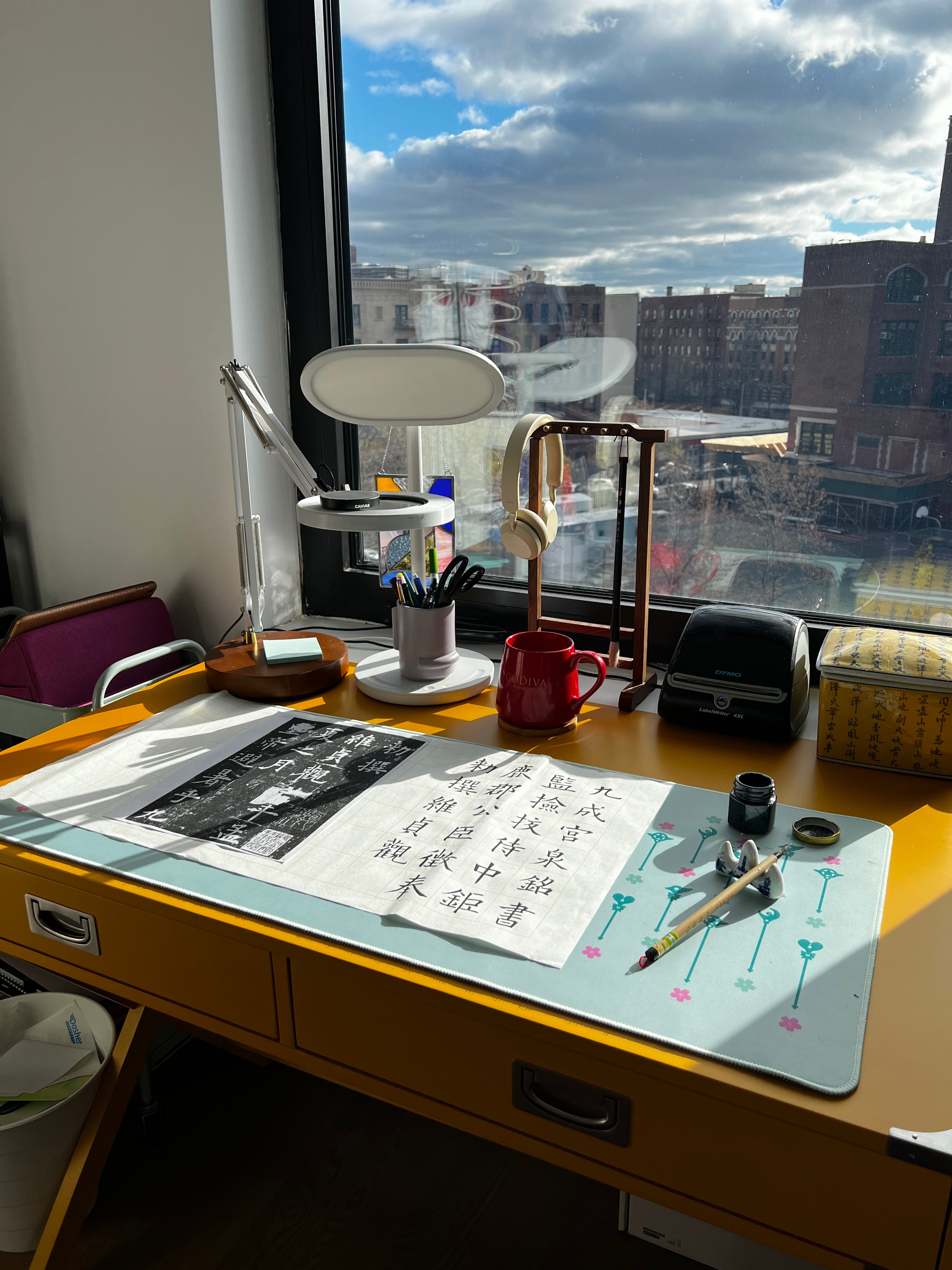 Bonnie's calligraphy table overlooking large window with sunlight streaming in